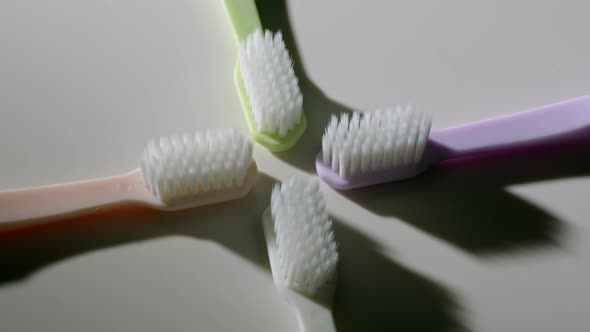 Four Toothbrushes Lying on Table and Spinning alt
