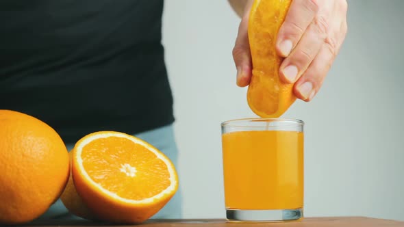 Cinemagraph seamless loop, male hand squeezing out fresh juice from orange citrus fruit