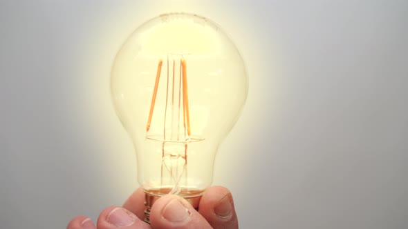 Caucasian Man Holding Glowing Incandescent Light Bulb