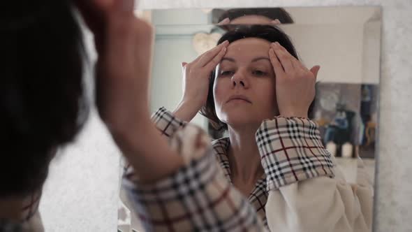 Portrait Of Healthy Woman Putting Moisturizing Cream On Face