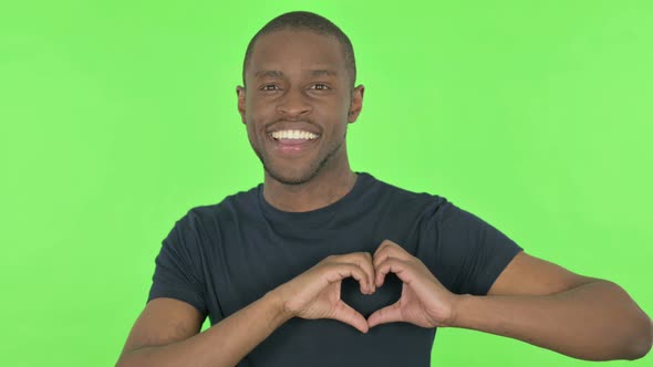 Handmade Heart By Young African Man on Green Background alt