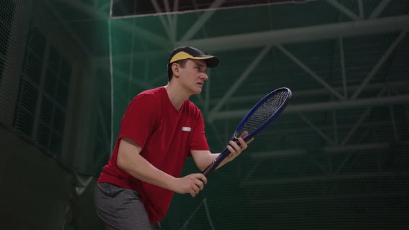 Sportsman is Playing Tennis on Indoor Court Waiting Serve of Opponent and Striking Ball By Racquet