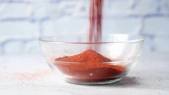 Pouring Chili Powder in Container on Table