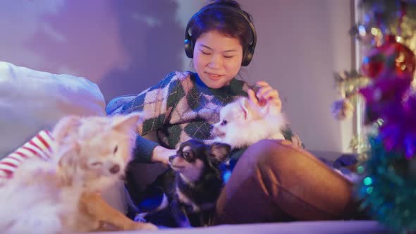 pretty asian female listen music frome headphone hand hug cute little lapdog
