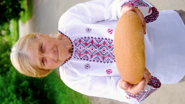 Grandmother with Ukrainian Bread in Her Hands alt