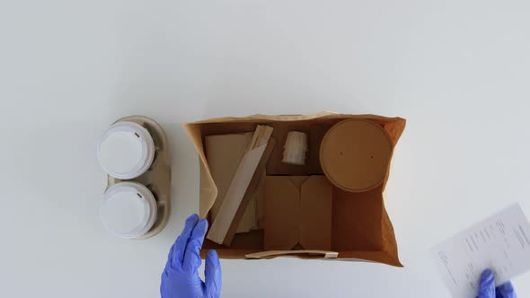 Hands in Gloves Packing Takeaway Food for Customer alt