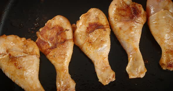 A Strip of Fried Chicken Drumstick in a Frying Pan Rotates.  alt