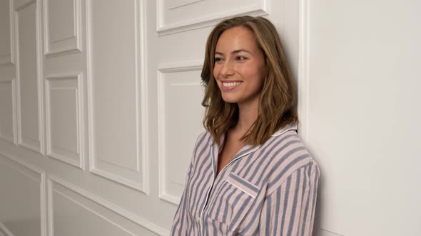 Woman Leaning on Wall Smiling alt