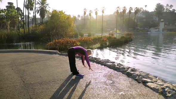 Senior Woman Working Out In The Park alt
