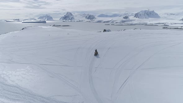 Aerial Flight Over Moving Snowmobile. Antarctica. alt