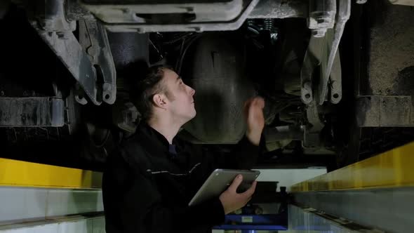 Car mechanic looks breakdowns, touches spare parts hand check their integrity alt