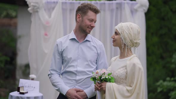 Happy Loving Newlyweds Looking at Each Other with Love Turning to Camera Smiling alt