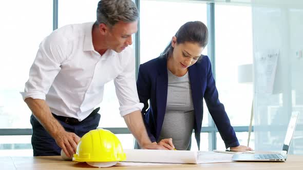 Architects working together on blueprint in a modern office 4k alt