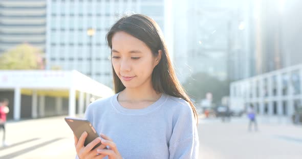 Woman look at cellphone at outdoor alt