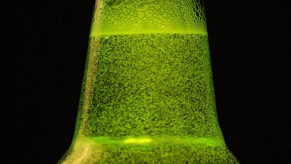 Green Bottle neck with a lot of bubbles is on black background