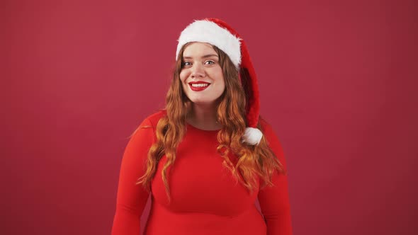 Smiling Plus Size Lady in Christmas Red Hat Waving Hands in Hello Gesture Greeting Friends Red alt