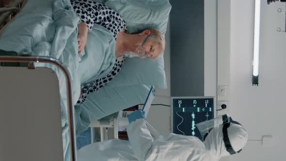 Vertical Video Medic with Protective Suit Checking on Heart Rate Monitor alt