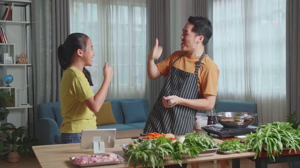 Asian Man Father And Daughter Cooking At Home, Food Tasting, Thumbs Up And Giving High Five alt