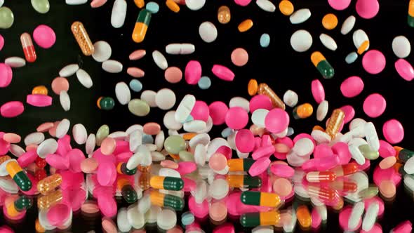 Super Slow Motion Shot of Falling Colorful Pills on Black Background at 1000Fps alt