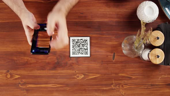Scanning QR Code in Restaurant Top View alt