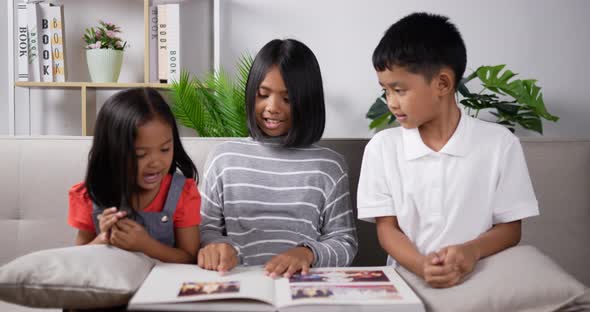Three kids reading a book. alt