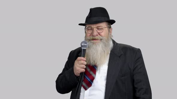 Smiling Old Senior Speaker with Long Beard Giving Speech with Microphone alt