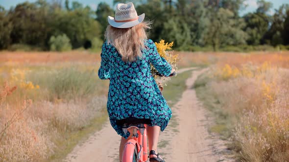 Woman Cyclist Riding On Bicycle And Having Fun. Woman In Hat Enjoying Summer. Bike With Basket. alt