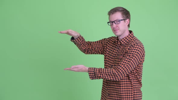 Happy Young Hipster Man Snapping Fingers and Showing Something alt