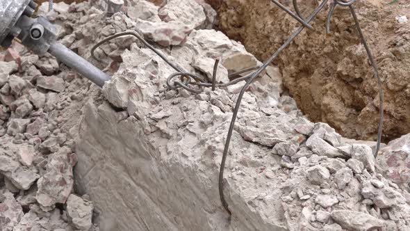 Demolition of a Jackhammer of a Concrete Structure at a Construction Site Closeup Top View alt
