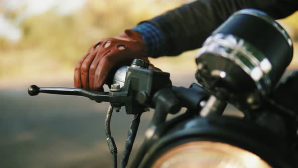 Closeup View of a Man's Hand in Brown Leather Mitts Starting the Engine alt