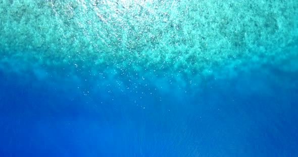 Daytime drone tourism shot of a white sand paradise beach and aqua turquoise water background in vib alt