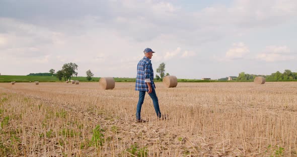 Farmer Using Digital Tablet While Examining Field alt