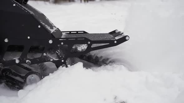 Snowbike Pulls Away and the Snow Flies in Different Directions alt