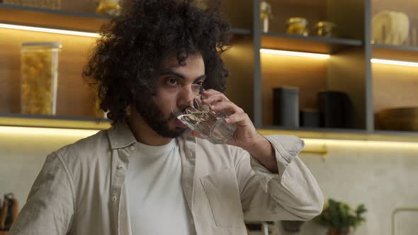 Egyptian Man Enjoys Drinking Water in Kitchen in Morning alt