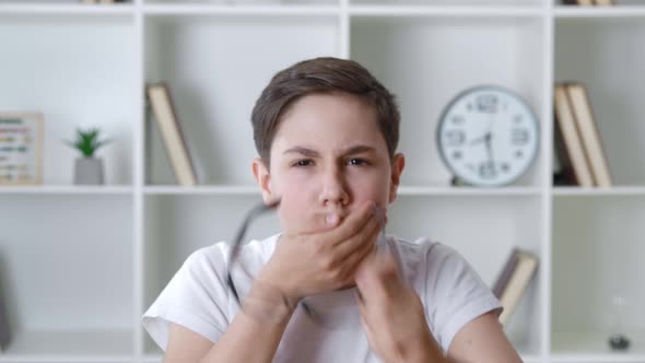 Afraid and Shocked Boy 13 Years Old in White Shirt Takes Off Glasses and Cover Mouth with His Hand alt