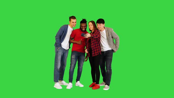 Multiracial Group of Young Friends Make Selfie and Laugh on a Green Screen Chroma Key alt