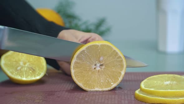 Woman slicing yellow lemon on chopping board closeup slow motion. Juicy lemon cut into slices. Cutti alt