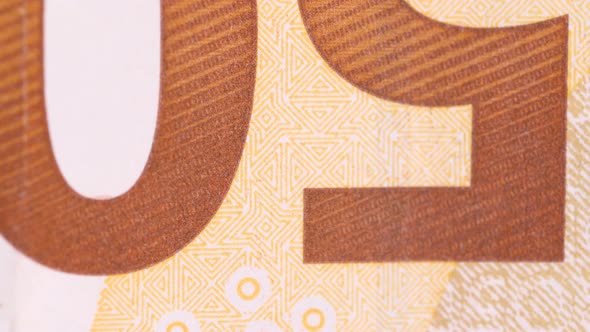 Macro shot of a fifty euro bill sign rotating clockwise direction. Extreme close up. alt