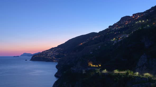 Sunset on the Amalfi Coast with the small town of Praiano on the left. Timelapse zoom in video. alt