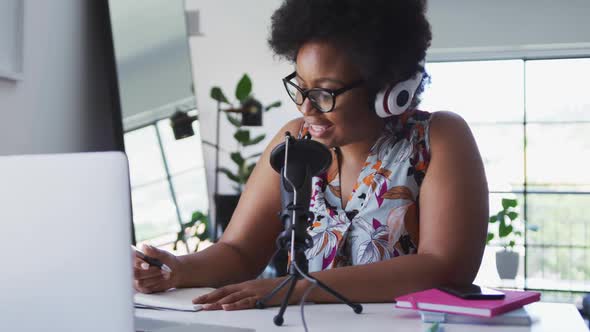 African american female plus size vlogger sitting using computer having a video chat alt