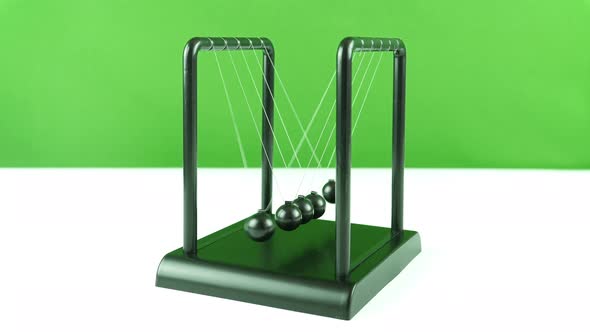 Table Pendulum Small Newton Balls On A Green White Background 2.
