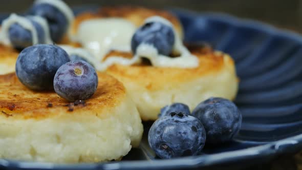 White Condensed Milk Flows on Cottage Cheese Pancakes with Blueberries