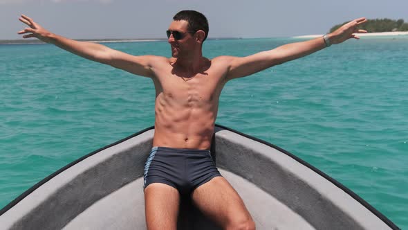 Young Successful Man with Arms Outstretched Enjoying on Deck of Boat at Ocean alt