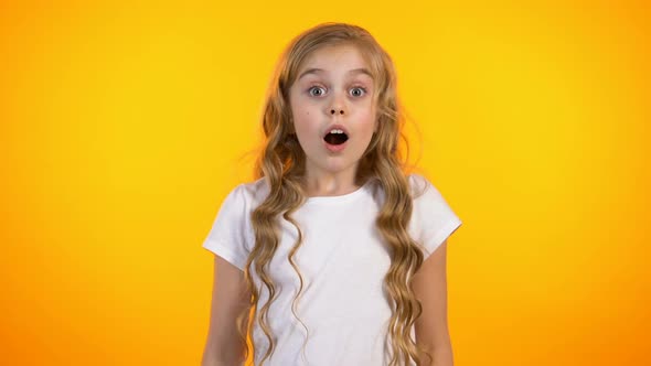 Shocked Cute Preteen Girl Peeping Through Fingers, Unexpected Surprise, Promo alt