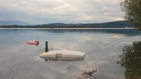 Static view of two capsized boats floating in Maggiore lake in Piedmont, Italy alt