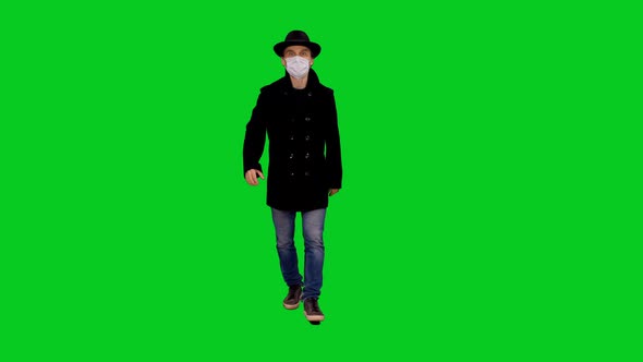 Casual Man In Stylish Clothing And Protective Mask Walking on Green Screen