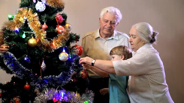 Little boy with grandmother and grandfather decorating christmas tree at home. Christmas,