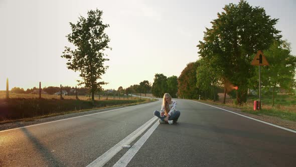 Young Woman Taking Selfie on Road. Lovely Young Lady Smiling and Posing for Selfie While Sitting on alt
