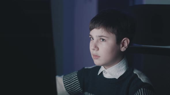 Year Old Boy Uses Computer at Night Home alt