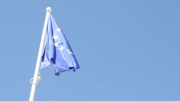 European Union flag in front of blue sky waving on wing 4K 2160p UltraHD footage - EU flag fabric ag alt